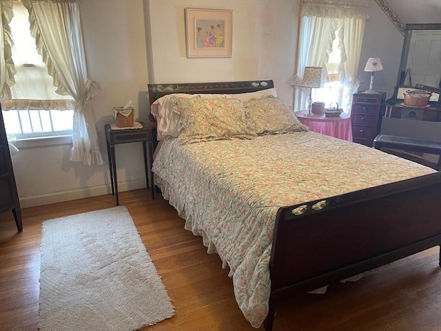 bedroom featuring wood finished floors and baseboards