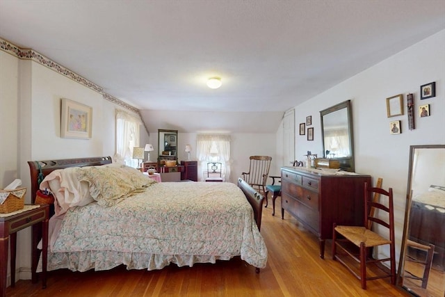 bedroom featuring lofted ceiling and wood finished floors