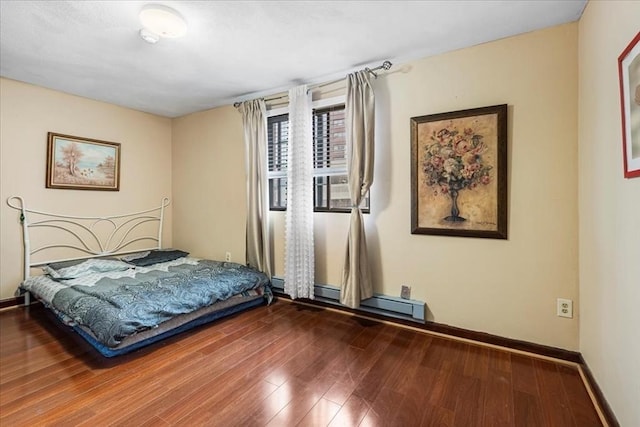 bedroom with wood finished floors, a baseboard radiator, and baseboards