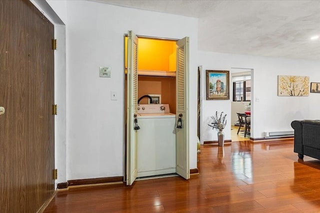 laundry room with washer / dryer, wood finished floors, a baseboard radiator, and baseboards
