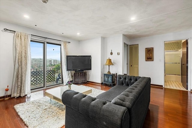 living area featuring baseboards, wood finished floors, and recessed lighting