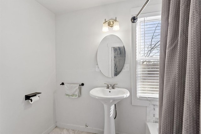 bathroom with shower / bathtub combination with curtain, sink, and a wealth of natural light