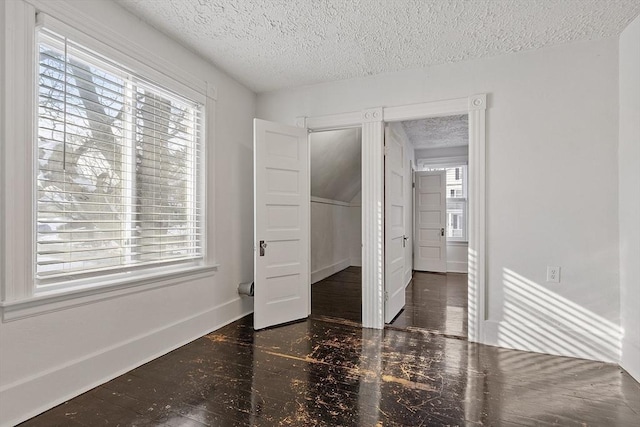 unfurnished bedroom with multiple windows and a textured ceiling