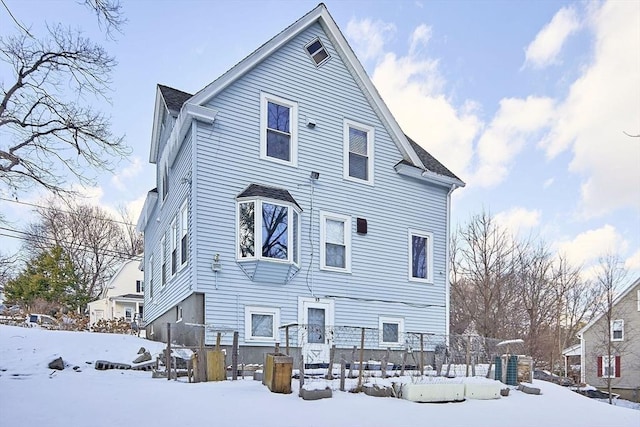 view of snow covered back of property