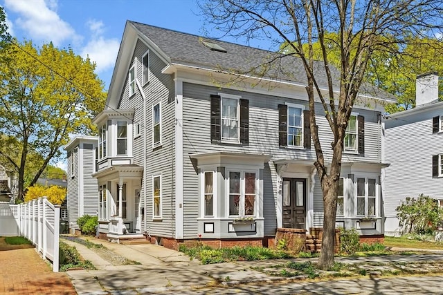 view of front of house featuring a shingled roof and fence
