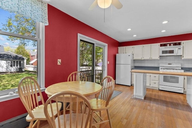 kitchen with white appliances, light wood-type flooring, recessed lighting, white cabinetry, and decorative backsplash