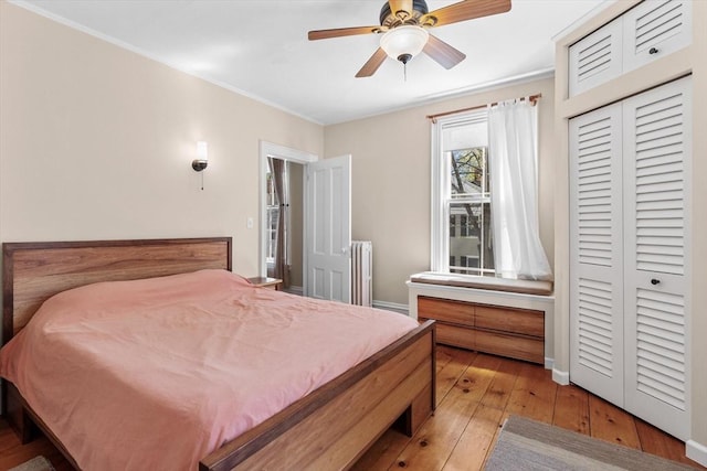 bedroom featuring light wood-style flooring, a ceiling fan, and ornamental molding