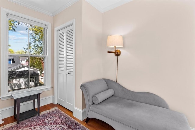 sitting room featuring wood finished floors, baseboards, and ornamental molding