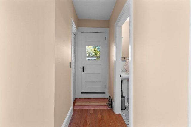 doorway featuring wood finished floors and baseboards