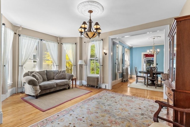 living room with baseboards, radiator, and a chandelier