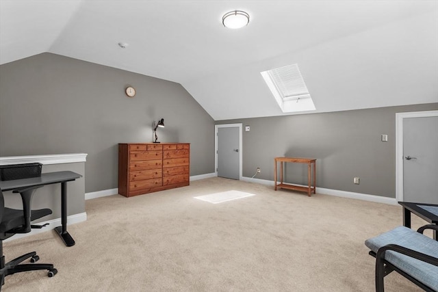 office with carpet floors, baseboards, and vaulted ceiling with skylight