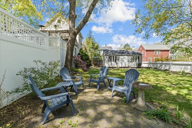 view of yard with a fenced backyard, a storage shed, and an outbuilding
