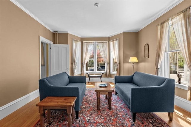 sitting room with crown molding, wood finished floors, and baseboards