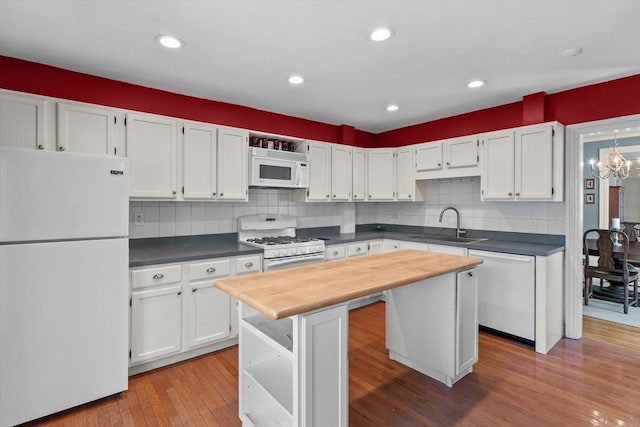 kitchen featuring a sink, white cabinets, white appliances, a kitchen island, and butcher block counters