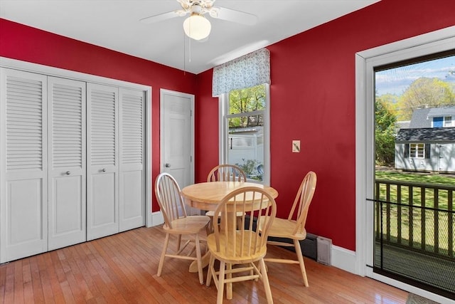 dining area featuring baseboards, light wood-style flooring, and a ceiling fan