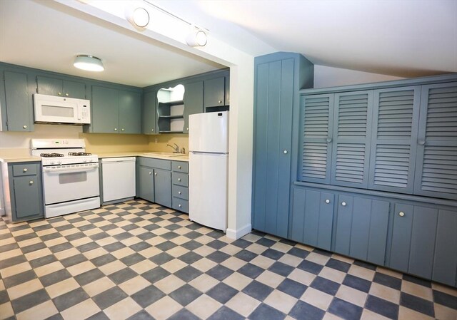 kitchen with vaulted ceiling, dark tile patterned flooring, baseboard heating, white fridge, and rail lighting