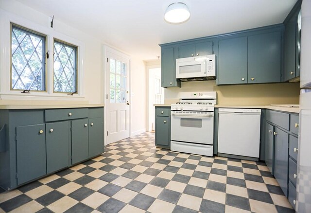 kitchen with sink, white appliances, green cabinets, and dark tile patterned flooring