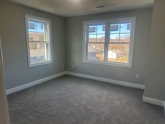 spare room with dark colored carpet