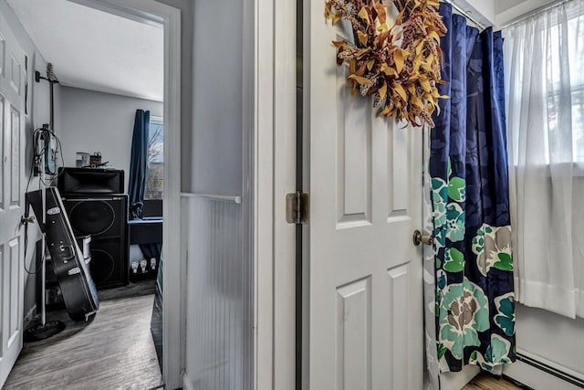 hall featuring a baseboard radiator and hardwood / wood-style flooring