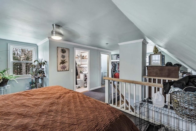 carpeted bedroom featuring lofted ceiling, connected bathroom, ornamental molding, and ceiling fan