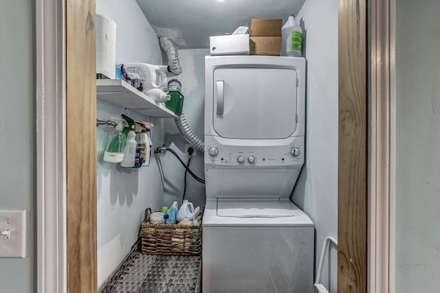 clothes washing area featuring stacked washer and clothes dryer and tile patterned floors