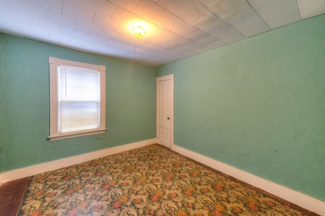 carpeted spare room featuring baseboards