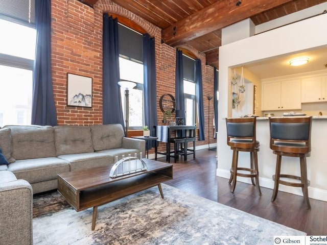 living room with beam ceiling, a high ceiling, wood ceiling, and dark hardwood / wood-style floors