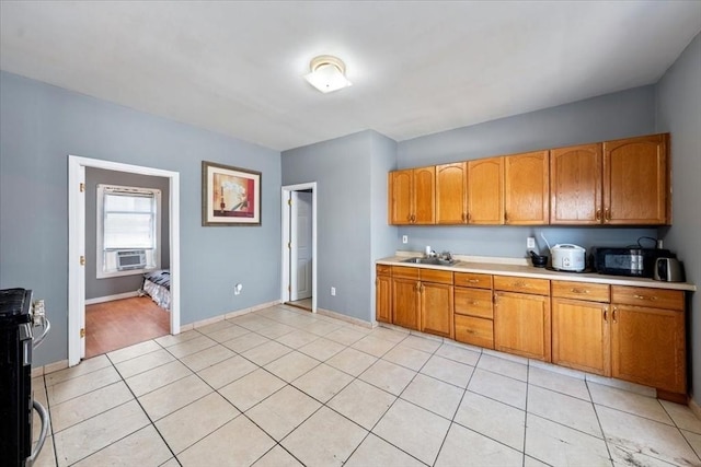 kitchen featuring light tile patterned floors, black appliances, and sink