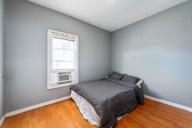 bedroom with cooling unit and wood-type flooring