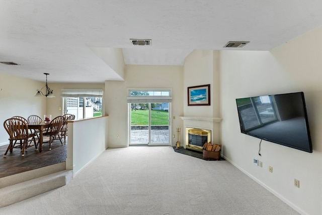 carpeted living room featuring a notable chandelier and lofted ceiling