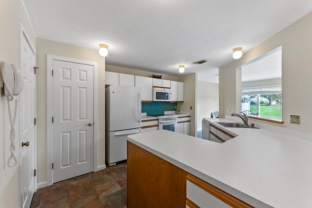 kitchen with white cabinets, sink, and white appliances