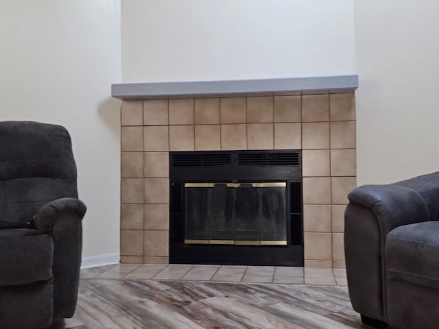 room details with wood finished floors and a tiled fireplace