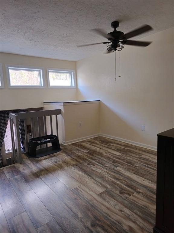 interior space with wood finished floors, ceiling fan, and a textured ceiling