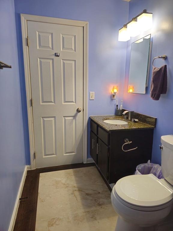 bathroom featuring vanity, toilet, and baseboards