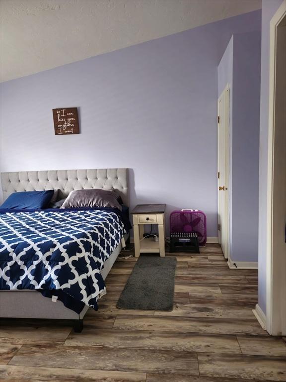 bedroom featuring wood finished floors and baseboards