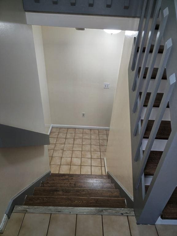 stairway with tile patterned flooring and baseboards