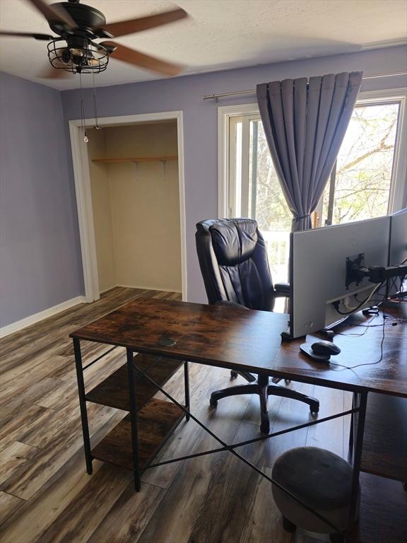 home office with baseboards, wood finished floors, and a ceiling fan