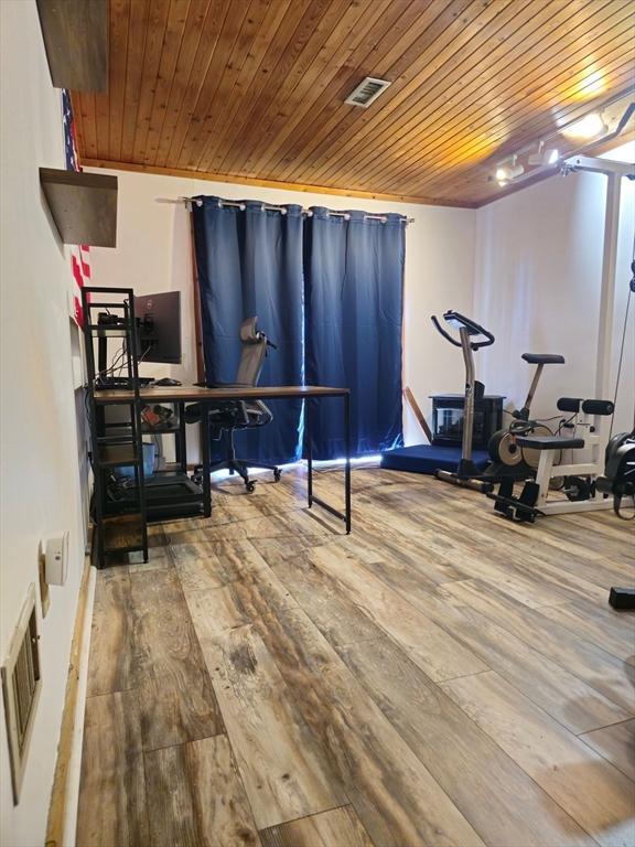 exercise room with visible vents, wood finished floors, and wood ceiling