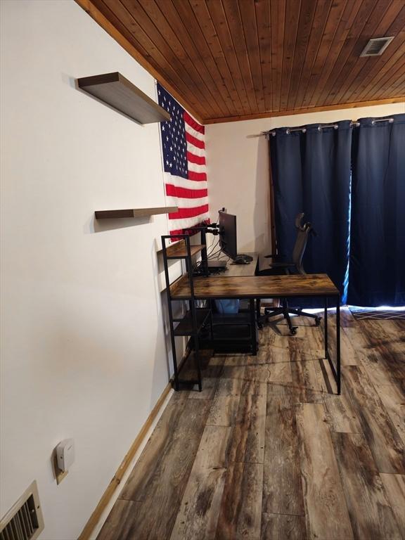 dining area with wood-type flooring, visible vents, wooden ceiling, and baseboards
