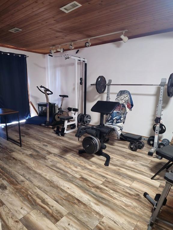 workout area featuring visible vents, wood finished floors, and wooden ceiling