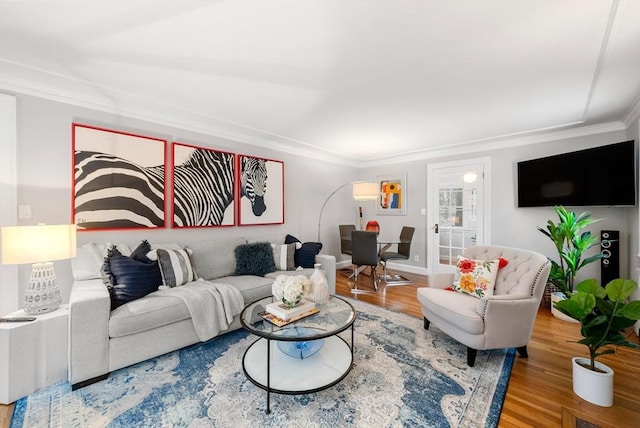 living room featuring wood-type flooring and crown molding