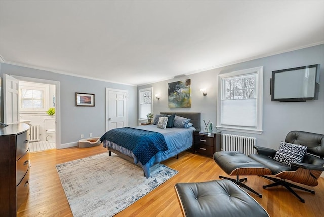 bedroom featuring ensuite bath, radiator heating unit, light hardwood / wood-style floors, and ornamental molding