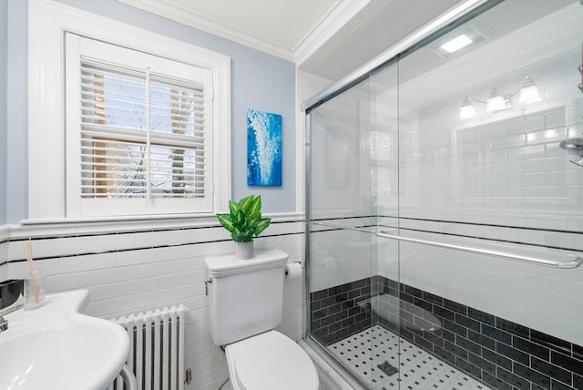 bathroom with radiator, toilet, ornamental molding, tile walls, and an enclosed shower