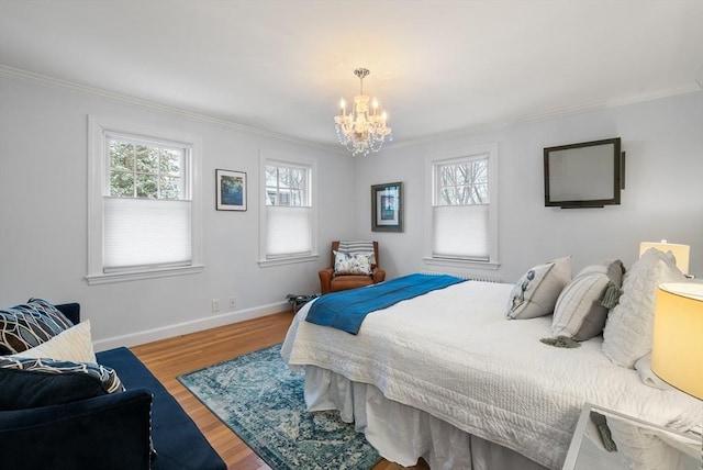 bedroom featuring hardwood / wood-style floors, a chandelier, and ornamental molding