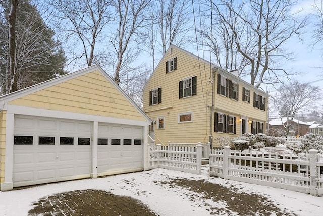 view of snow covered exterior with a garage and an outdoor structure