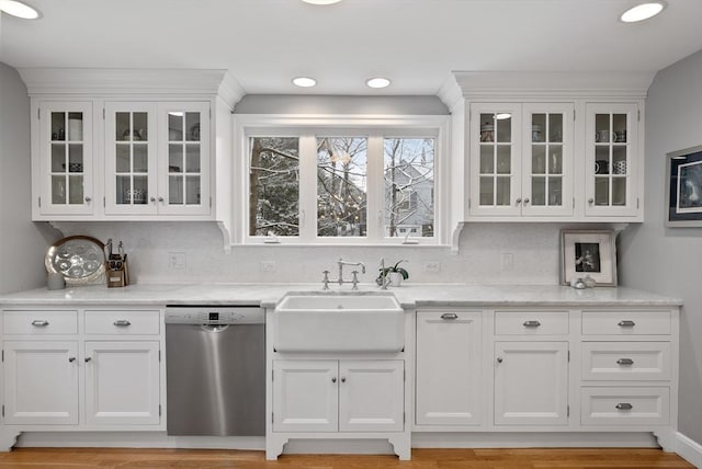 interior space with white cabinets, dishwasher, backsplash, and sink