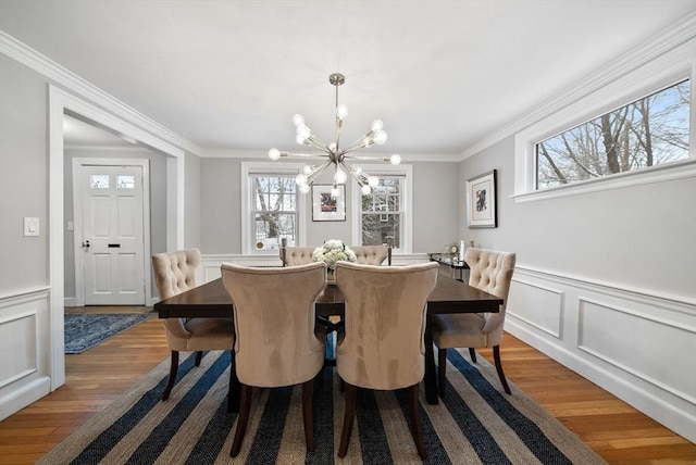 dining area with a chandelier, hardwood / wood-style flooring, and ornamental molding