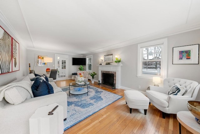 living room with hardwood / wood-style flooring, a fireplace, and ornamental molding