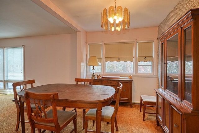 dining room featuring light colored carpet and a notable chandelier