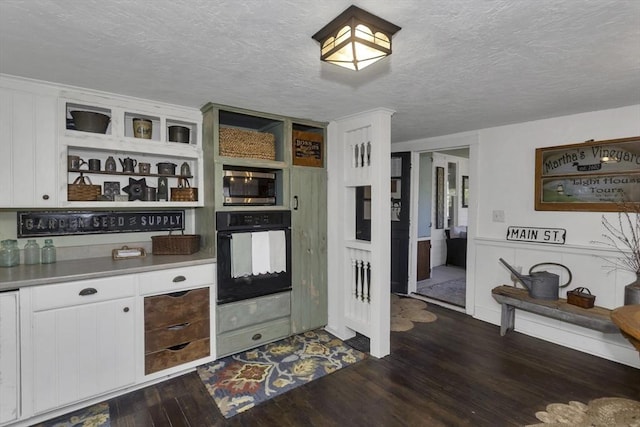 685 Main St, Wilbraham, MA 01095 - kitchen with oven, stainless steel microwave, white cabinetry, a textured ceiling, and dark wood-type flooring